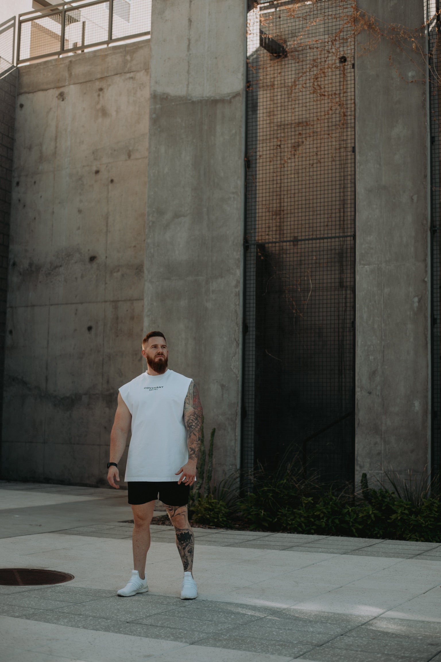 Model wearing the Brushed White Cut Off Tee with shorts. The Cut Off is an oversized fit with a longer hemline and boxier fit. 