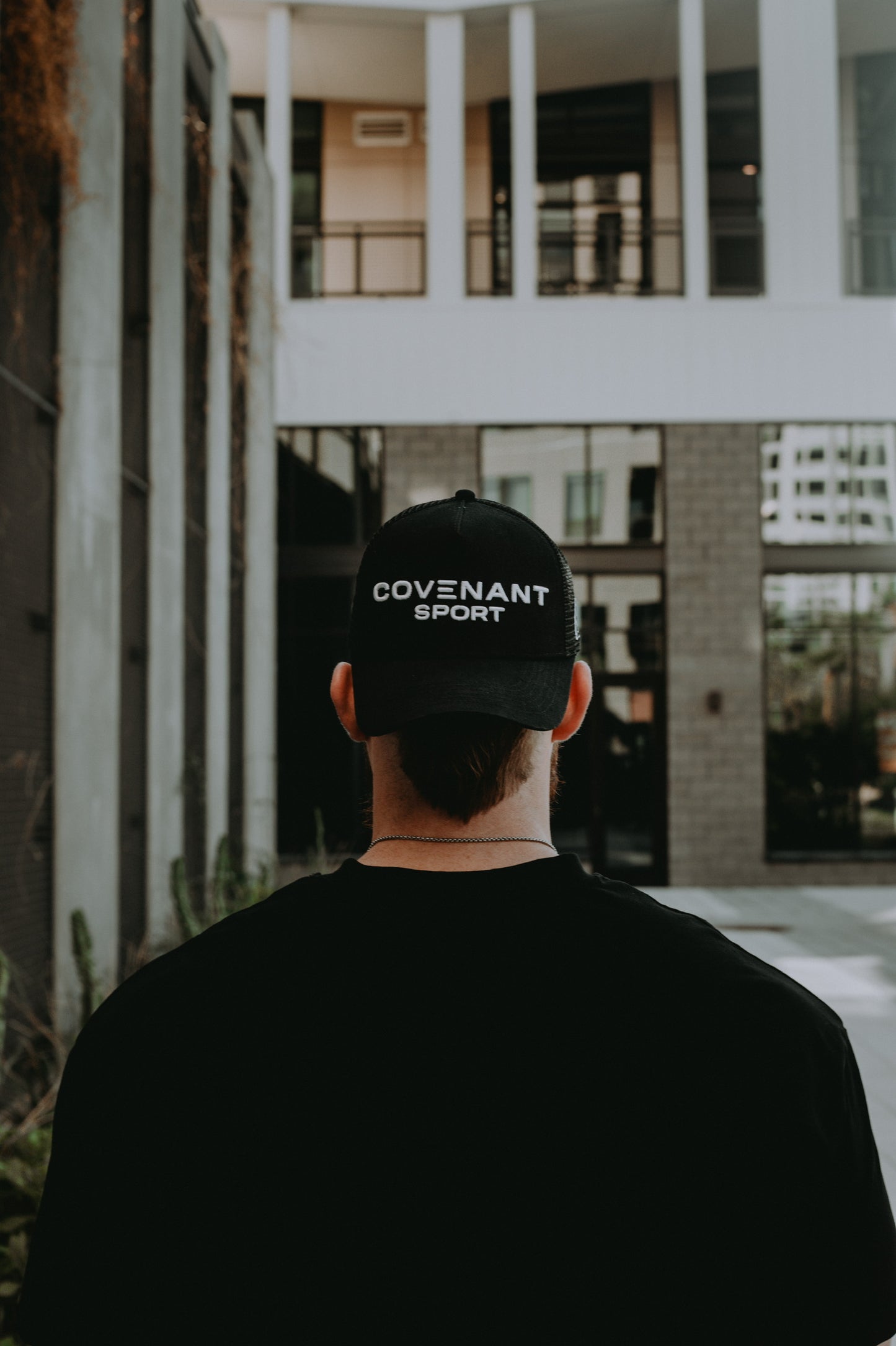 Male model showing the front of the Original Trucker Hat with the "Covenant Sport" branding.