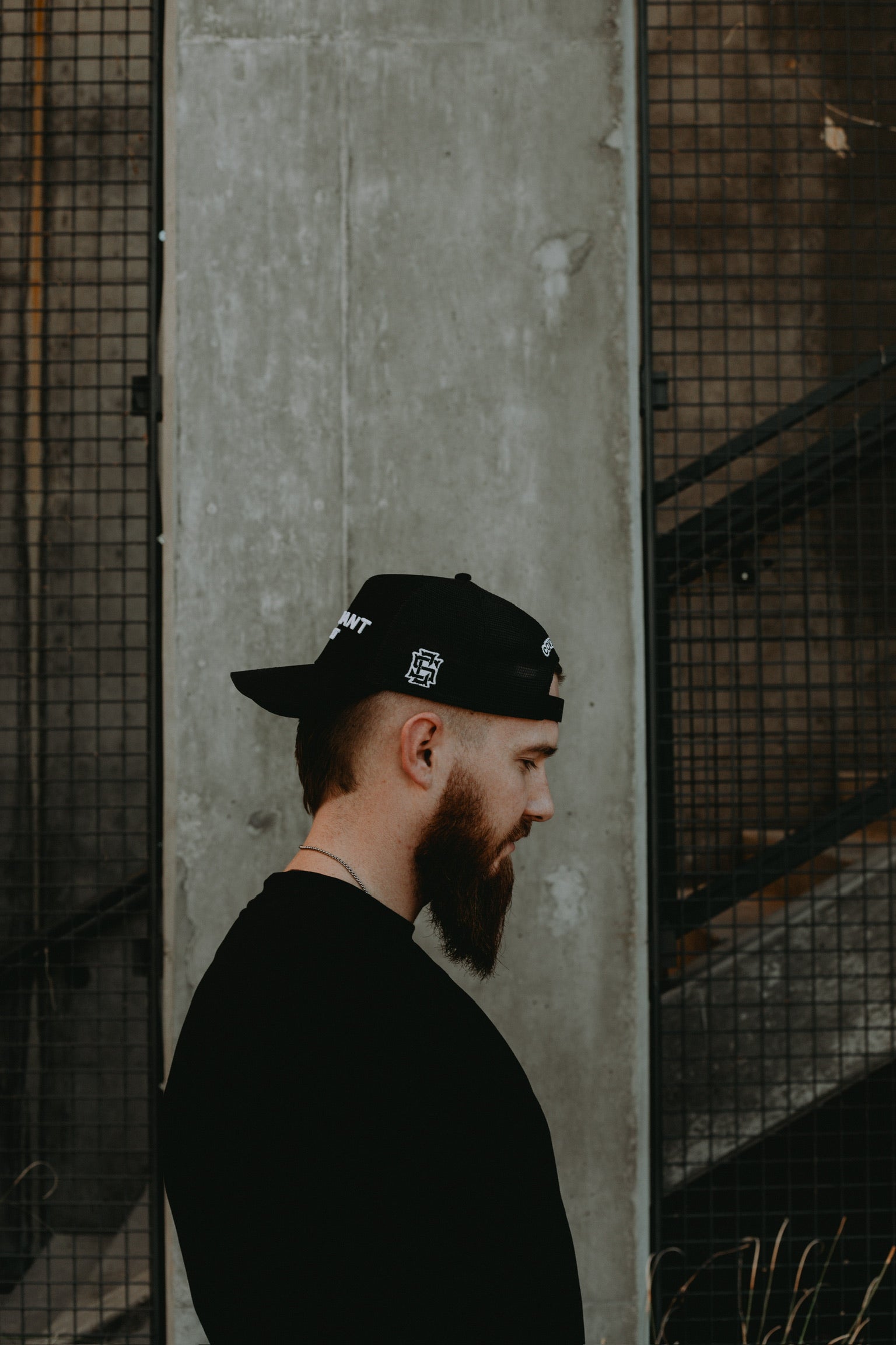 Male model with backwards Original Trucker Hat showing the "CS" logo on the left side of the hat.