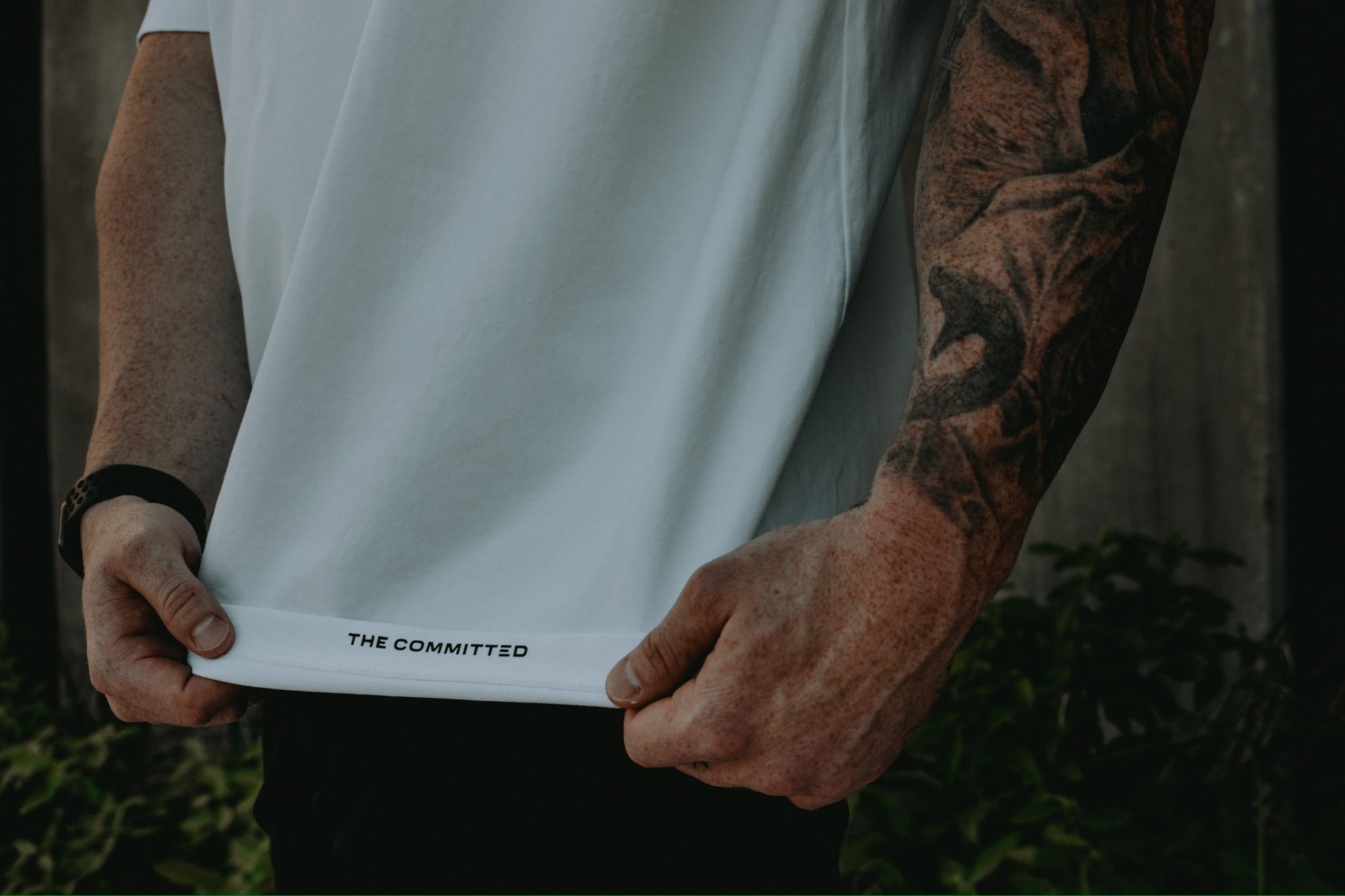 "The Committed" printed on the inside hem of each tee. 